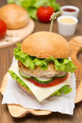 homemade chicken burger with vegetables, cheese, sauces