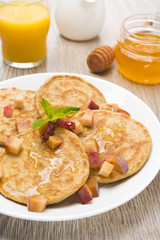 pancakes with peaches and honey for breakfast on the plate