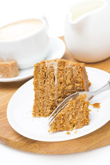 piece of honey cake on a plate, cream and cappuccino