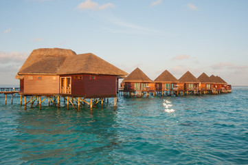 the sun rise over water bungalows in amazing water villas