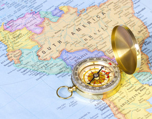 gold compass on map of South America