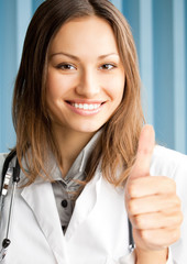 Young female doctor with thumbs up gesture