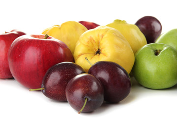 Quinces with apples and plums isolated on white