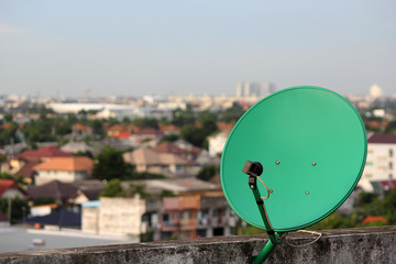 Green satellite dish evening. On the roof deck of the building.