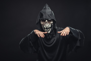skeleton in a black robe with glasses dancing