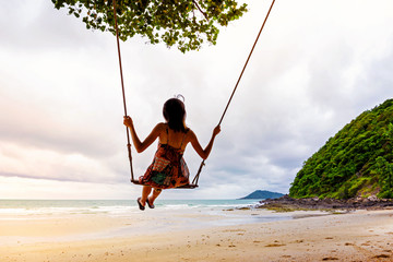 Girl playing the swing on beach