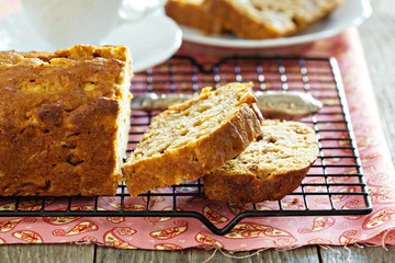 Cake with pieces of apples sliced on a cooling rack
