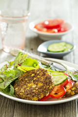 Vegan chickpeas burgers with salad and vegetables