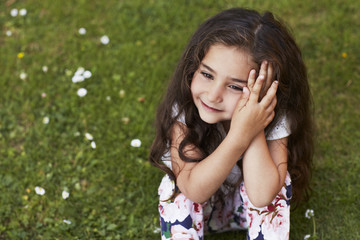 Naklejka premium Young girl sitting on grass
