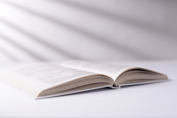 Open white book on a white surface