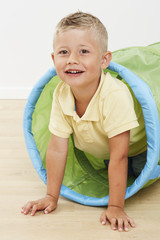 Young boy playing in toy tunnel