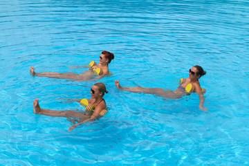 Happy active fitness people doing exercise with aqua dumbbell
