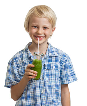 Cute boy drinking green smoothie