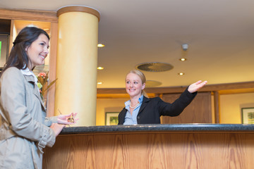 Smiling receptionist helping a hotel guest