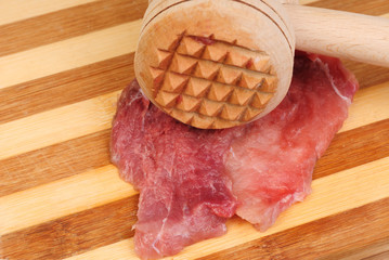 a wooden hammer for beating the meat