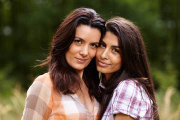 Mother and daughter staying cheek to cheek