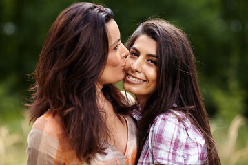 Mother kissing her daughter on the cheek