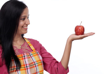 Happy young woman holding red apple against white