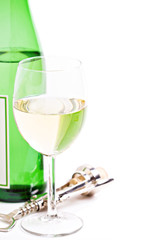 A glass of white wine with bottle and corkscrew