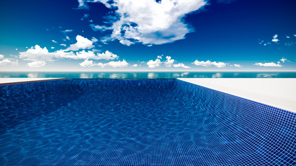 Infinite swimming pool with ocean in background