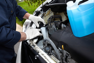 Hands of auto mechanic with wrench.