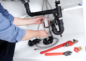 Hands of Plumber with a wrench.