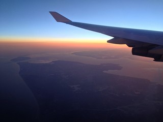 Obraz premium Wing of plane on sunrise background