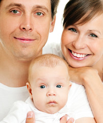 Happy young family with baby. Indoors.