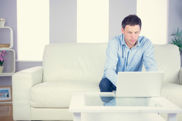 Attractive casual man using laptop
