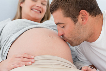 Close up of a future dad kissing the belly of his wife