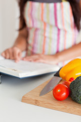 Young female consulting a notebook while standing
