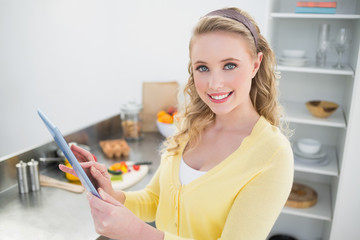 Smiling cute blonde holding tablet