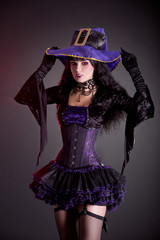 Smiling witch in purple and black gothic Halloween costume