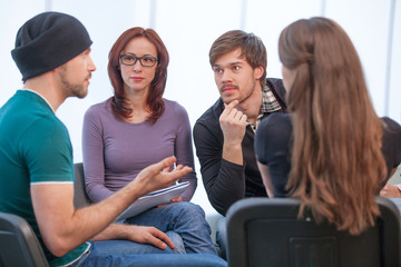 Group of people listening to what young man saying
