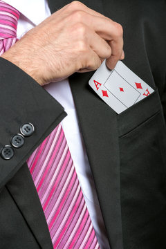 businessman pulling out his pocket aces cards