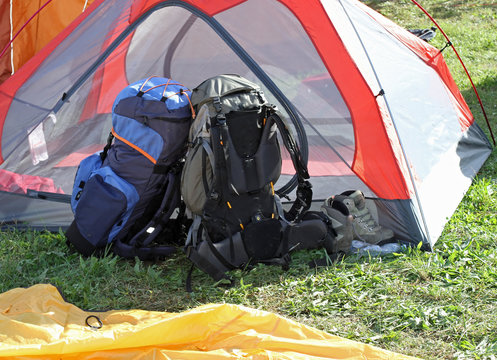backpacks of hikers resting above the tent