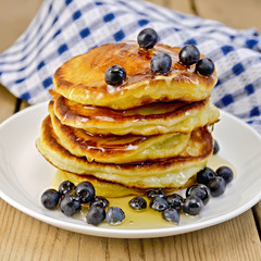 Flapjacks with blueberries and honey on the board