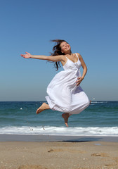 Fototapeta na wymiar beautiful pregnant woman jumping on the beach