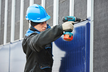 worker assembling facade metal construction