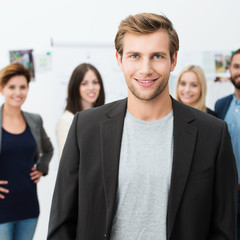 junger mann im büro mit team im hintergrund
