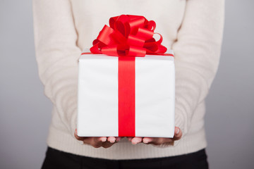 Female hands holding small gift with ribbon