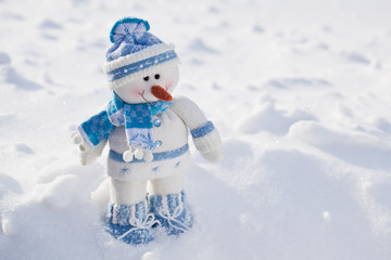 Little snowman with carrot nose in the snow.