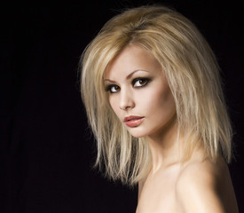 Fototapeta premium Fashion blonde woman with makeup and hairstyle over black