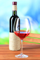 Glass of wine on wooden table  on nature background