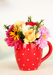 Beautiful bouquet of bright flowers in color mug,