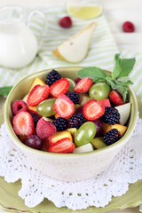 Fruit salad in plates on wooden table near napkin