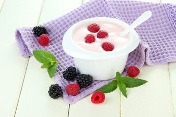 Delicious yogurt with berries on table close-up
