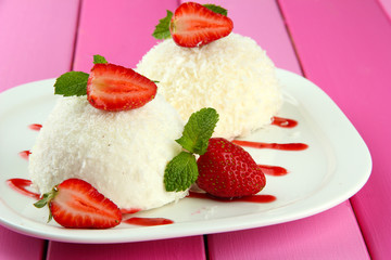 Delicious coconut cakes on plate on table close-up