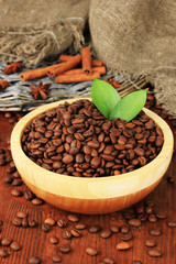 Coffee beans in bowl on wooden background