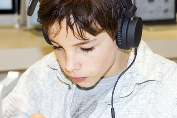 Portrait of a sweet young boy listening to music on headphones